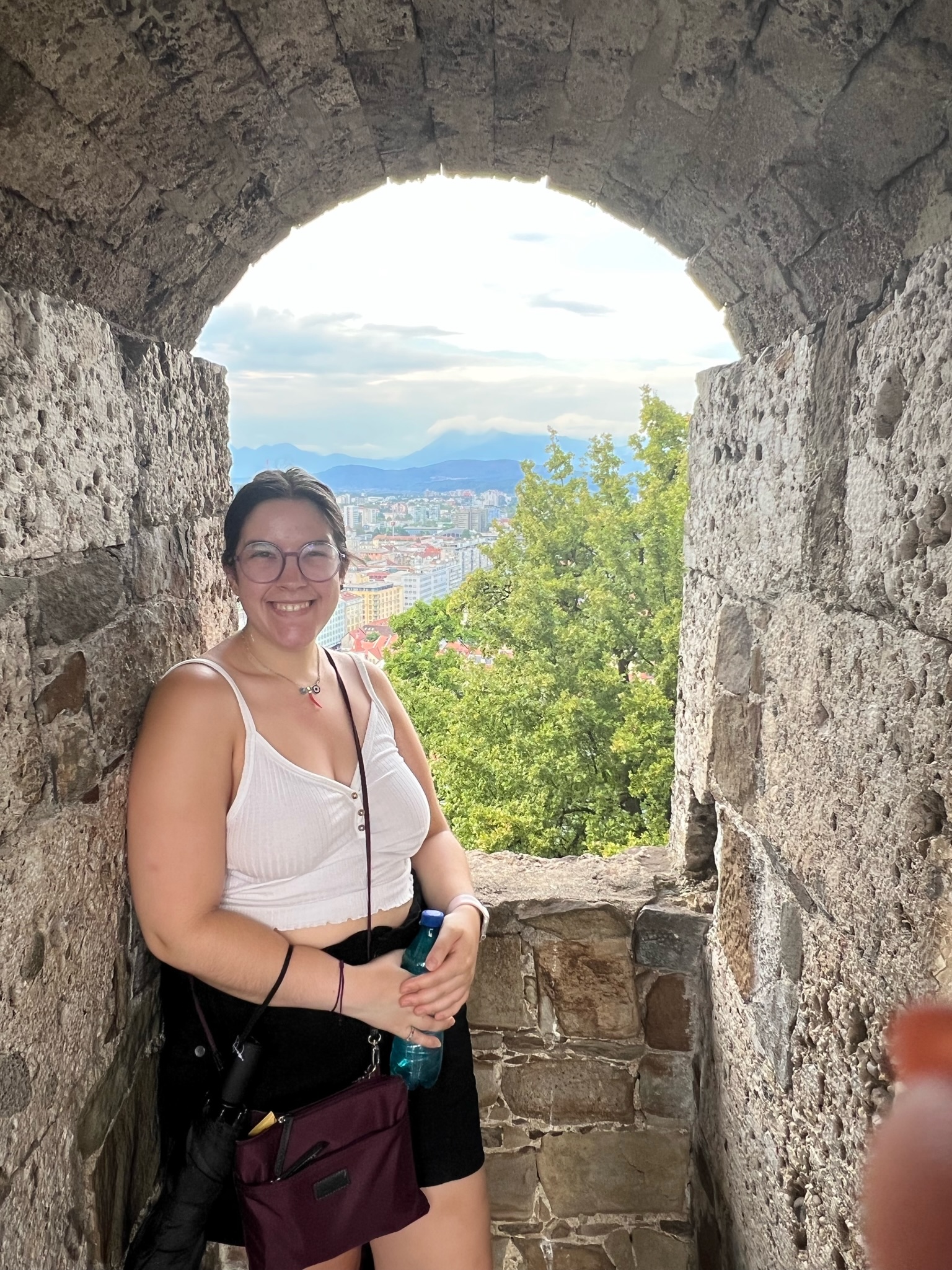 Stone archway of Ljubljana Castle with city skyline visible through the opening