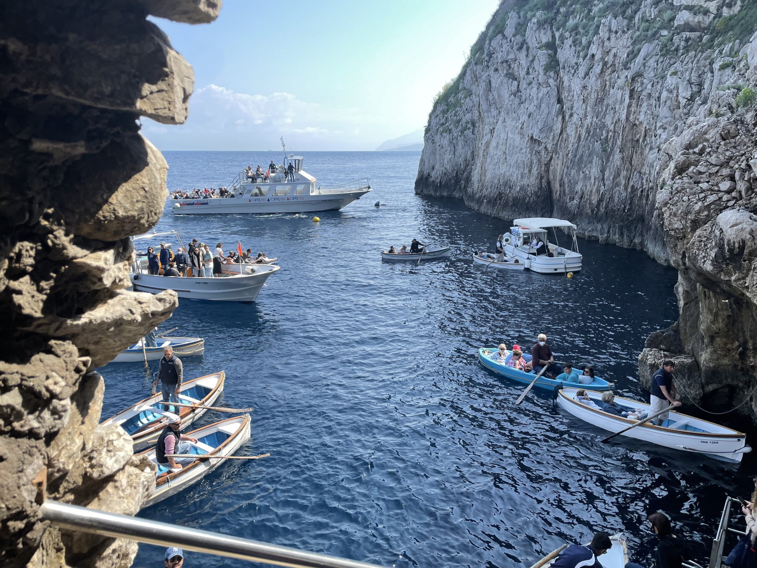 Small rowboats waiting outside the Blue Grotto entrance at Capri