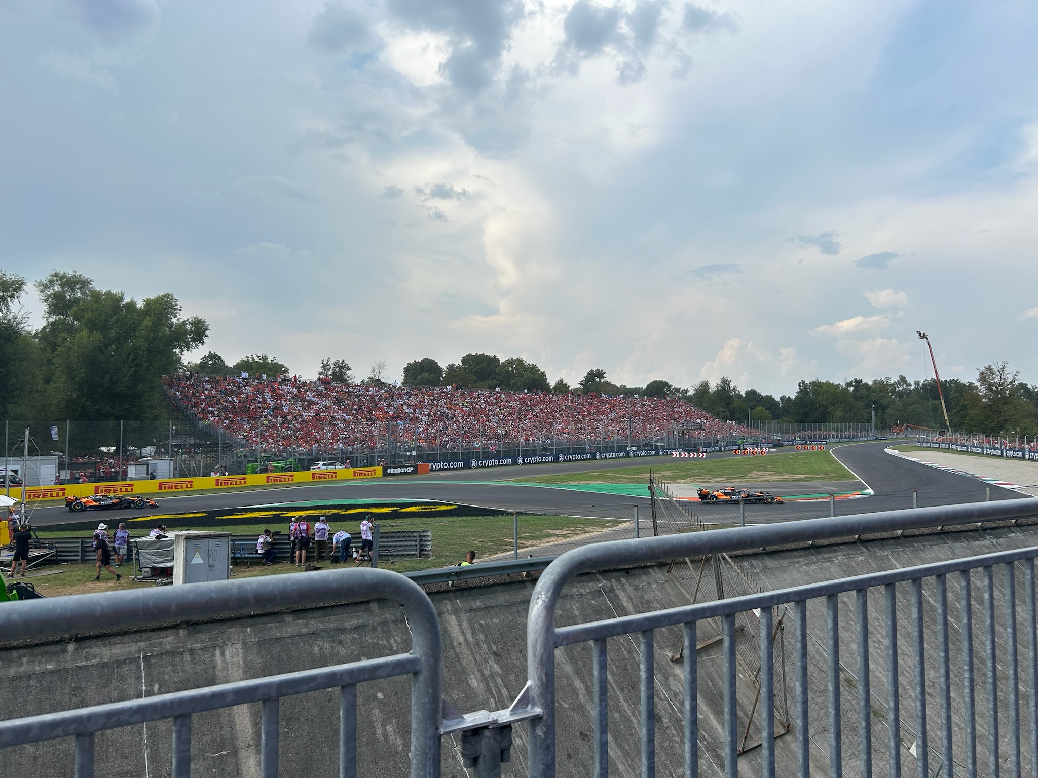 Monza circuit with cars racing past packed grandstands full of tifosi