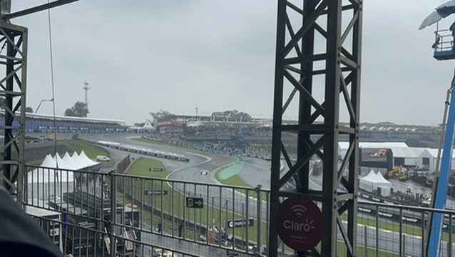 Interlagos 2024, the wet race from the grandstand &mdash; cars on a soaking track with the whole amphitheatre in view.